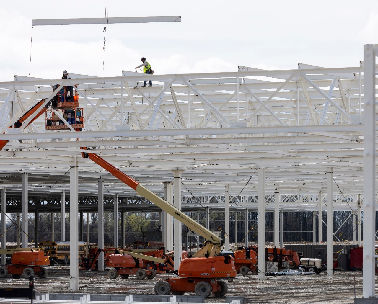 View of construction workers on unfinished roof of Blue Oval City facility